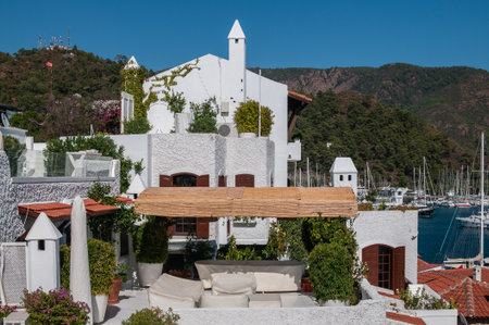 Picturesque white Mediterranean style houses with red tiled roofs and terraces with lush vegetation...