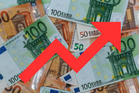 Red arrow on a background of euro banknotes. Business concept.