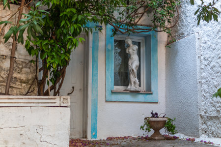 The courtyard of an old house with sculptures, greenery and flowersの写真素材