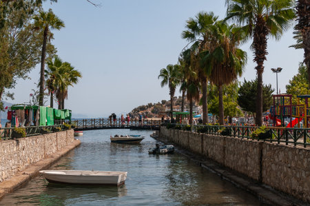 Picturesque canal in the coastal village of Turunc with lush greenery, flowers and mountainsの写真素材