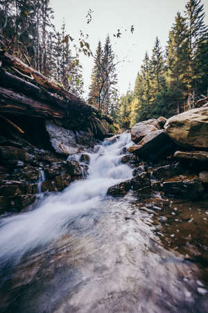 A large waterfall in a forest a mountainの写真素材