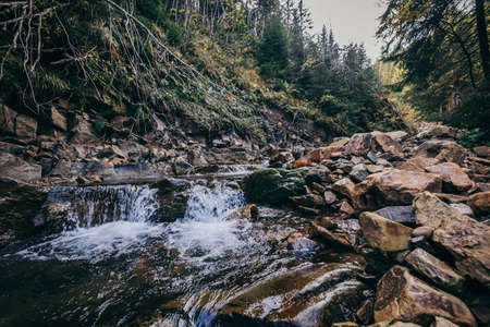 A large waterfall in a forest a mountainの写真素材