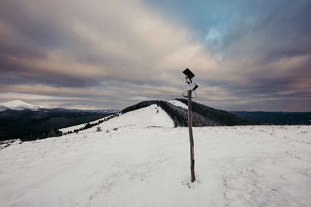 A sign on the side of a snow covered slope
