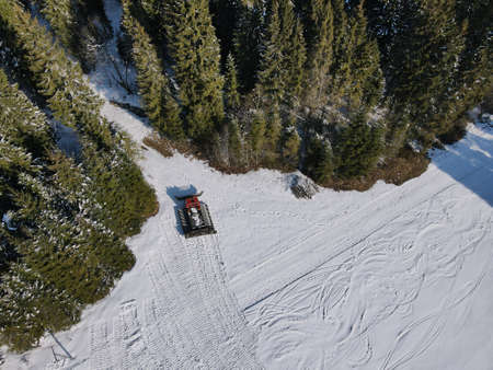 A man riding a snowboard down a snow covered slopeの写真素材