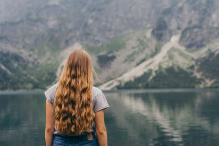 A person standing in front of a body of waterの写真素材