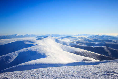A man flying through the air on a snow covered mountainの写真素材