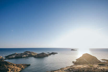 A rocky shore next to a body of waterの写真素材