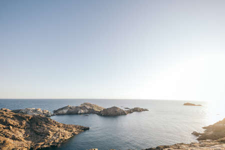 A rocky island in the middle of a body of waterの写真素材