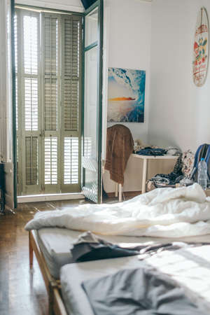 A bedroom with a bed and a windowの写真素材
