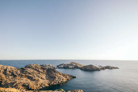 A rocky island in the middle of a body of waterの写真素材