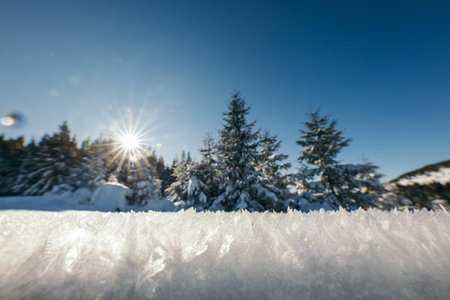 A man riding a snowboard down a snow covered slopeの写真素材