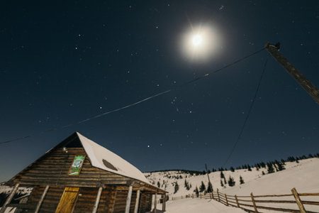A sign above a snow covered slope