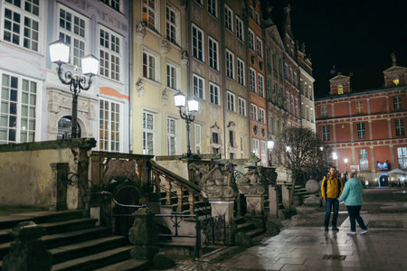 A group of people walking down a street next to a building