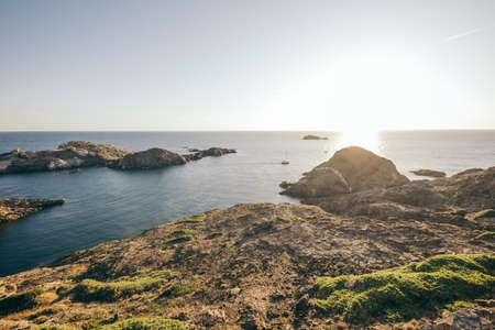 A rocky shore next to a body of waterの写真素材