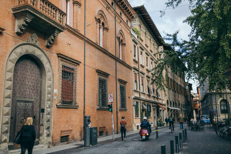 A group of people walking down a street in front of a brick buildingの写真素材