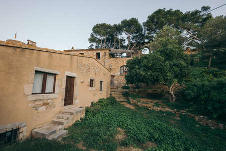 A large brick building with grass in front of a houseの写真素材