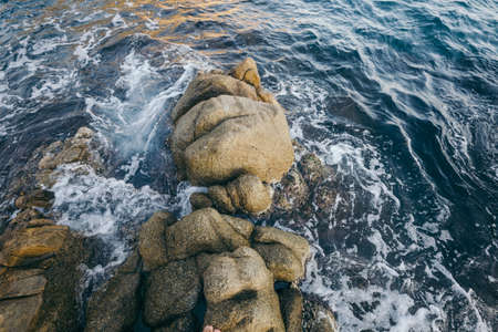 A close up of a rock next to water
