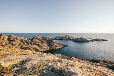A rocky beach next to a body of waterの写真素材