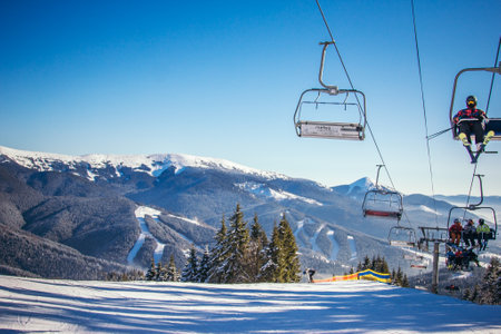 A group of people riding skis on top of a snow covered slopeの写真素材