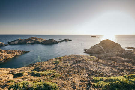 A rocky shore next to a body of waterの写真素材