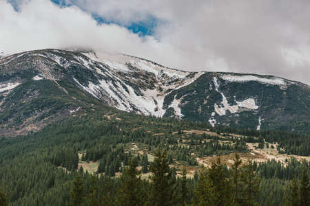 A train covered in snow with a mountain in the backgroundの写真素材