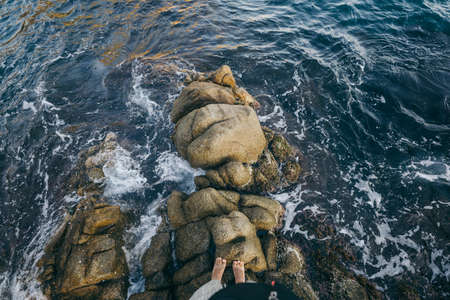 A man standing on a rock in the waterの写真素材