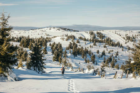 A group of people riding skis on top of a snow covered slopeの写真素材