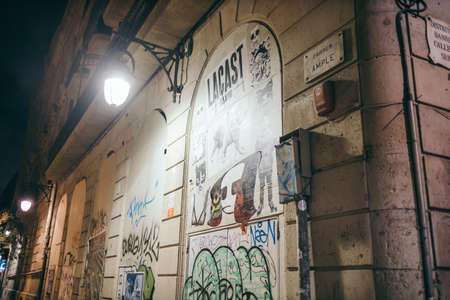 A narrow city street with graffiti on the side of a buildingの写真素材