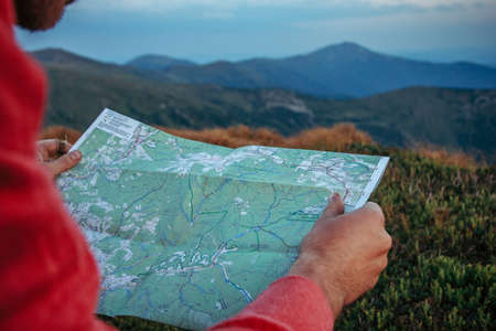 A man holding a sign in front of a mountainの写真素材