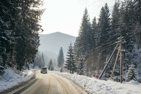 A path with trees on the side of a snow covered slopeの写真素材