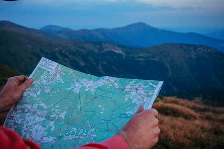 A man holding a sign in front of a mountainの写真素材