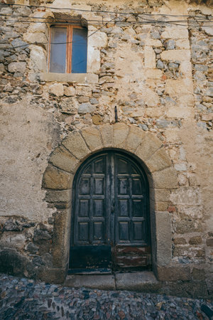 A stone building that has a clock on the side of a brick wallの写真素材