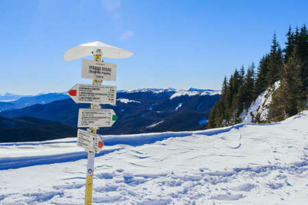 A sign on the side of a snow covered slopeの写真素材