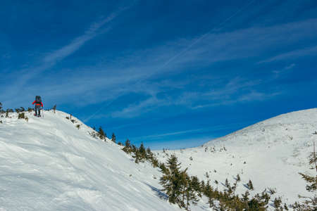 A man riding a snowboard down a snow covered slopeの写真素材
