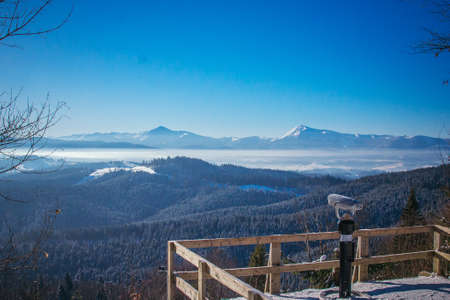 A sign above a snow covered mountainの写真素材
