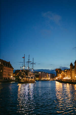 A boat is docked next to a body of waterの写真素材