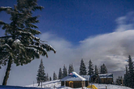 A person riding a snowboard down a snow covered slopeの写真素材