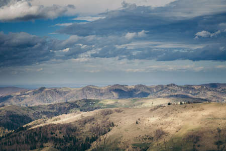 A group of clouds in the sky over a mountainの写真素材
