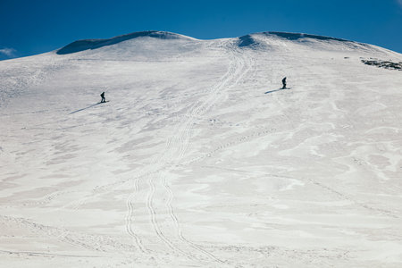 Snow in the mountains, skiers spring and winterの写真素材