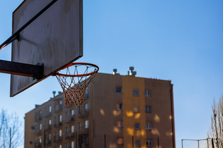 Basketball backboard with a basket in front of a multi-storey building. High quality photo