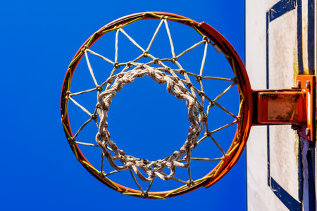 Basketball hoop with net against blue sky background. bottom view. High quality photoの写真素材