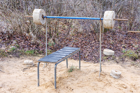 A barbell made of rebar and concrete and a bench press. An improvised outdoor gym.の写真素材