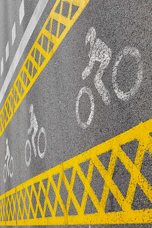 a yellow bike path crosses the roadの写真素材