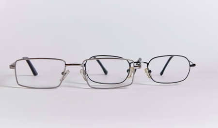 Two pairs of glasses are arranged one after another, like two people. Glasses close-up isolated on a white backgroundの写真素材