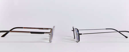 Two pairs of glasses look like people are at each other and want to say something. Glasses close-up...