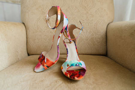 Colored sandals are on beige armchairの写真素材