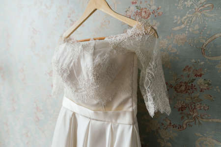 Lace top wedding dress hanging on the wallの写真素材