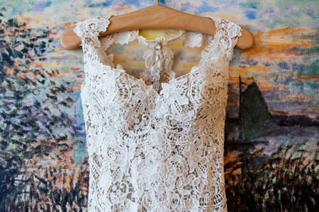 Lace top wedding dress hanging on the wallの写真素材