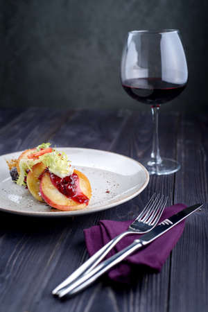 Goose liver with cherry sauce and apples and a glass of wineの写真素材