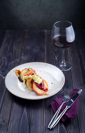Goose liver with cherry sauce and apples and a glass of wineの写真素材